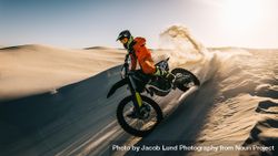 Motocross bike rider accelerating over sand dune 4mn17b