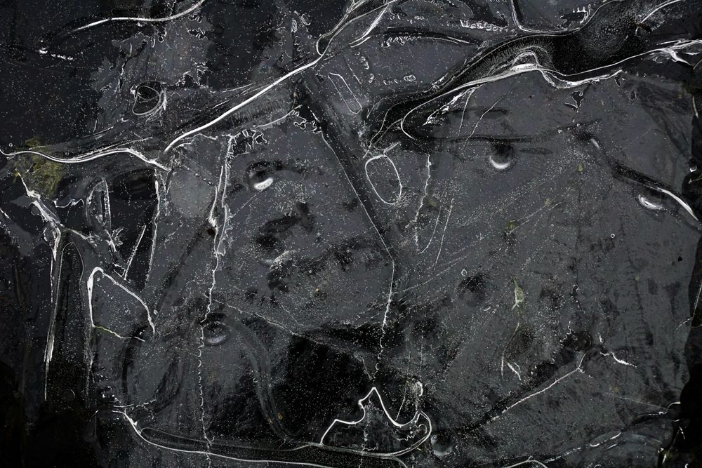 Fragment of thin ice on dark frozen river