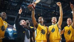 Multiethnic Basketball Players Celebrate Championship Victory with Hugs, Jumping, And Holding the Trophy.