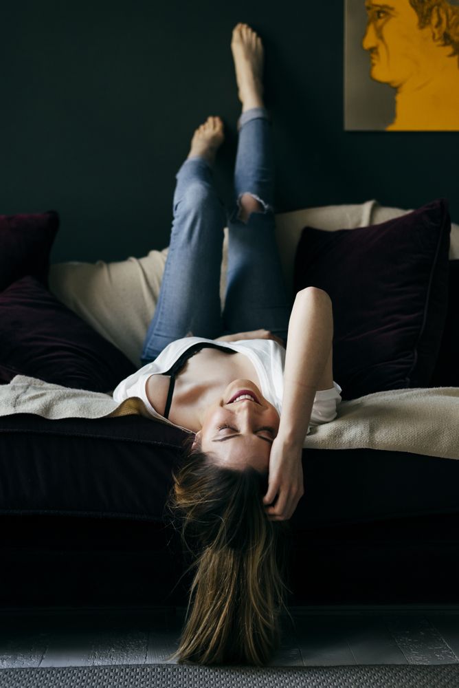 Cheerful woman lying on sofa