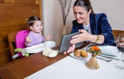 Businesswoman mother and baby girl looking tablet
