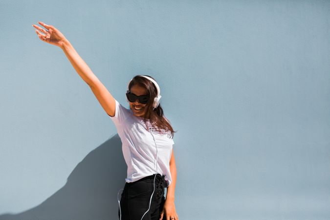 Cheerful casual woman in sunglasses standing on city street