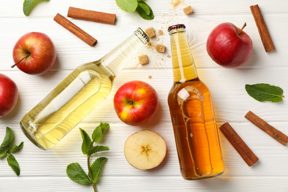 Composition with cider, cinnamon and apples on wooden background