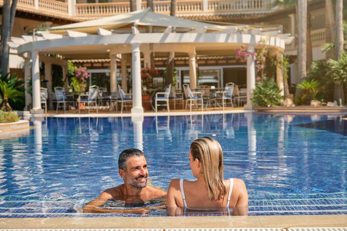Couple resting in pool of resort hotel