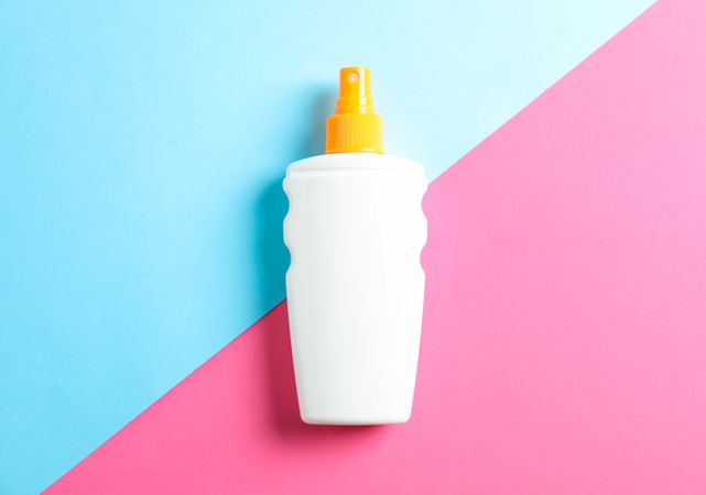 Sunscreen spray on two tone background, space for text