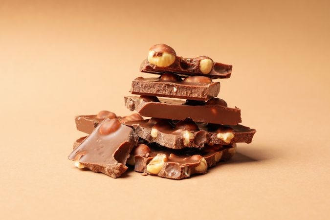 Chocolate pieces on beige background. Sweet food