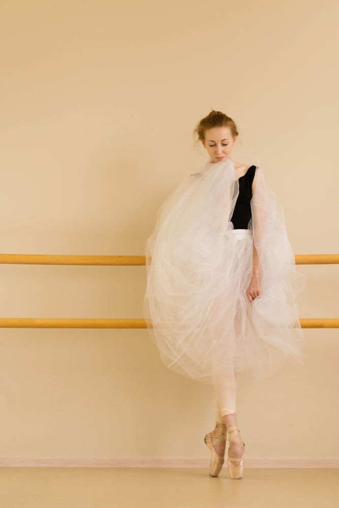 Ballet dancer showcases graceful stance in serene studio setting