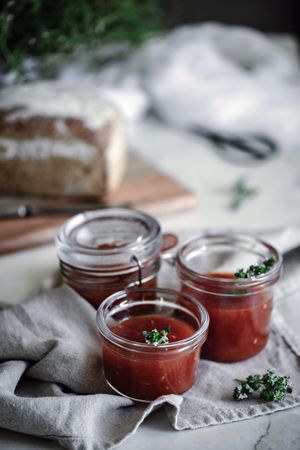 Fresh bread on napkin near tomatoes jam