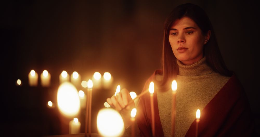 Devout Christian Woman Lighting a Candle in Church, Praying and Expressing Devotion to the Lord.