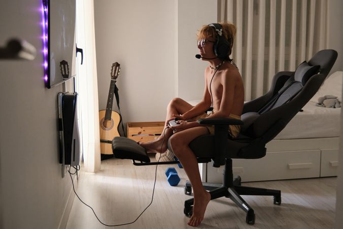 Concentrated happy young man sitting playing games