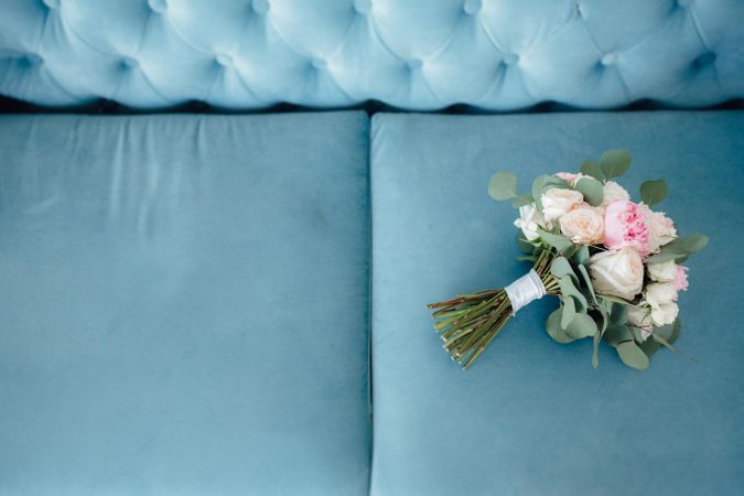 Pink flower bouquet on blue couch