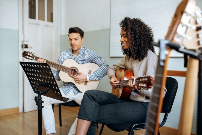 Man and woman playing guitar in studio