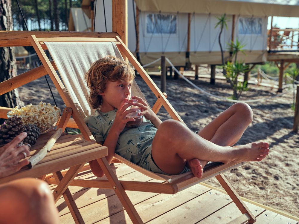 Boy drinking beverage on deckchair