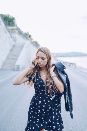 Long haired stylish woman speaking on smartphone