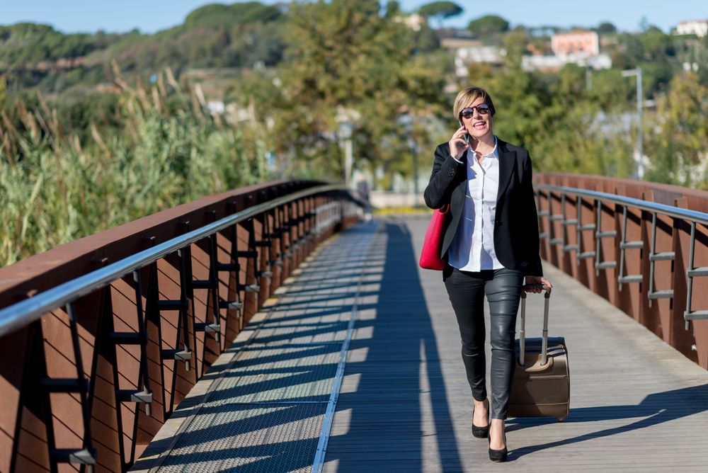 Happy woman standing outside speaking on phone