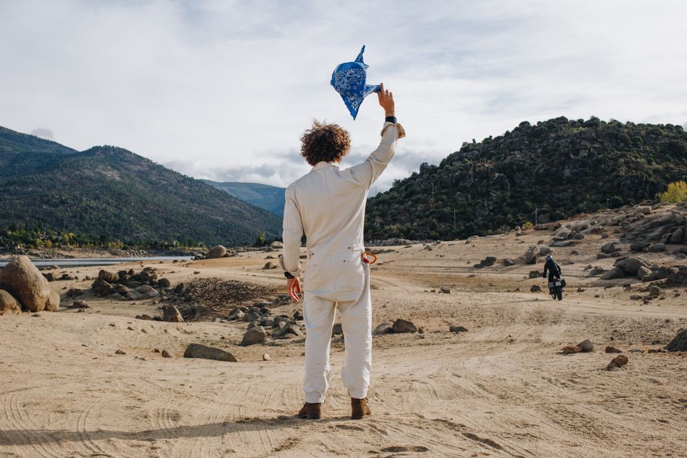 Back of man in jumpsuit with blue flag