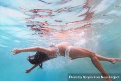 Underwater shot of pregnant woman swimming 0yO3G4