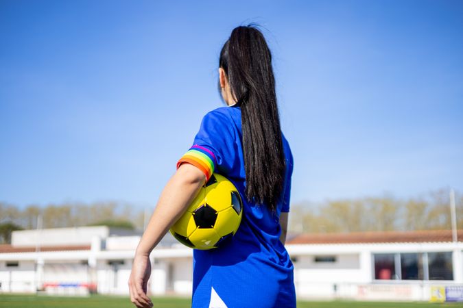 Female soccer player with captain armband with LGBT pride flag