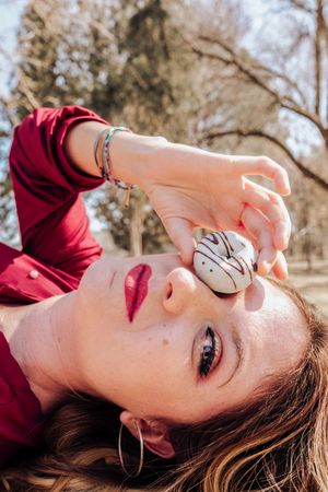 Woman looking through donuts hole on picnic