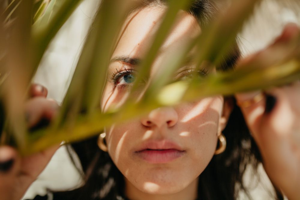 woman behind palm leaf