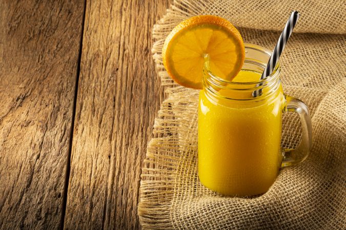 Glass with orange juice on the table.