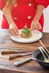 Crop woman with delicious steak tartar in kitchen