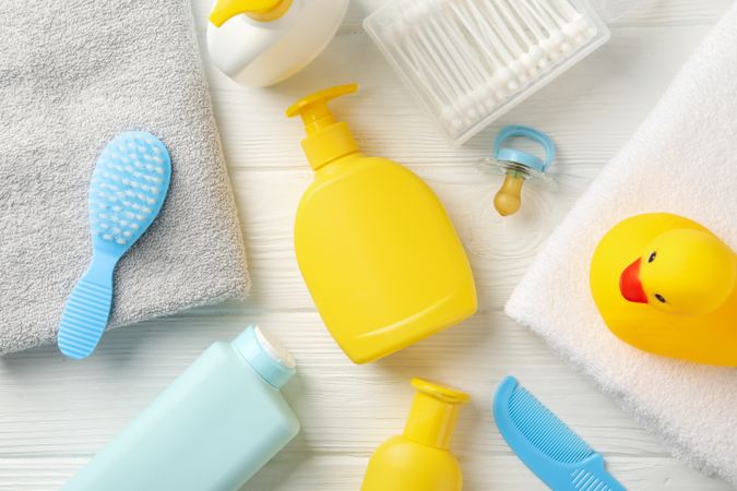 Baby hygiene accessories on wooden background, top view