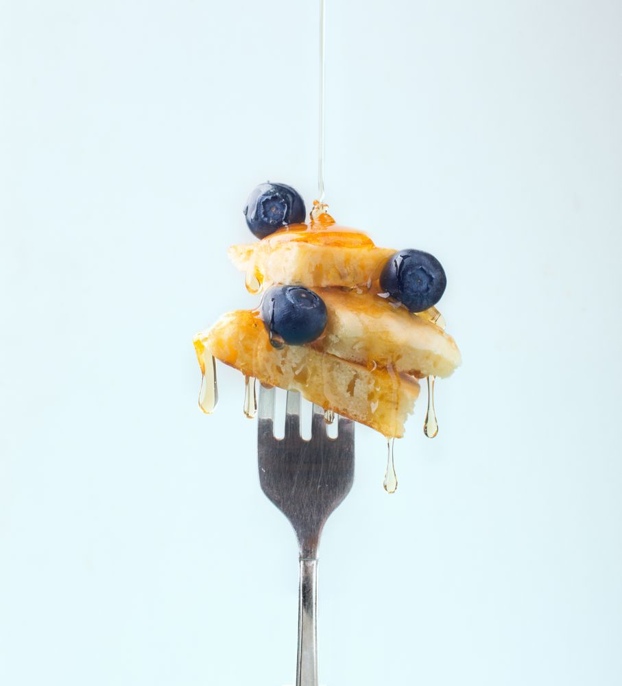 Appetizing fruit dessert with honey on fork