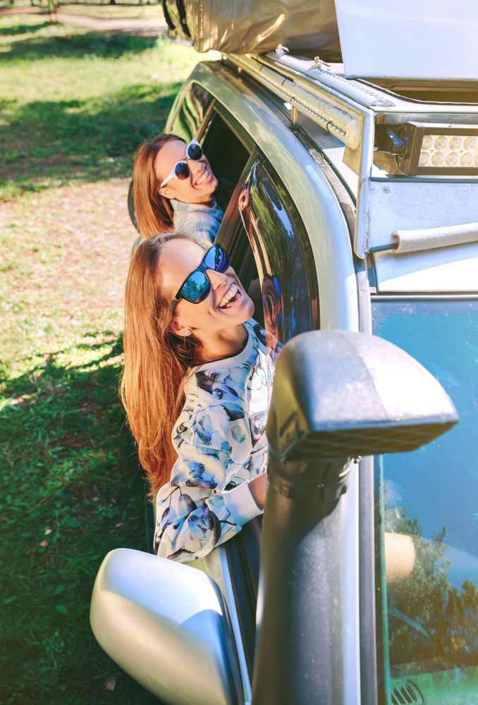 Happy women having fun through the window car