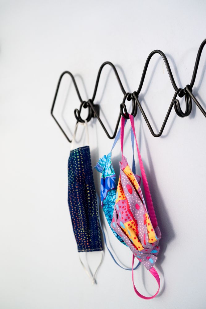Covid masks hang on coat rack at home