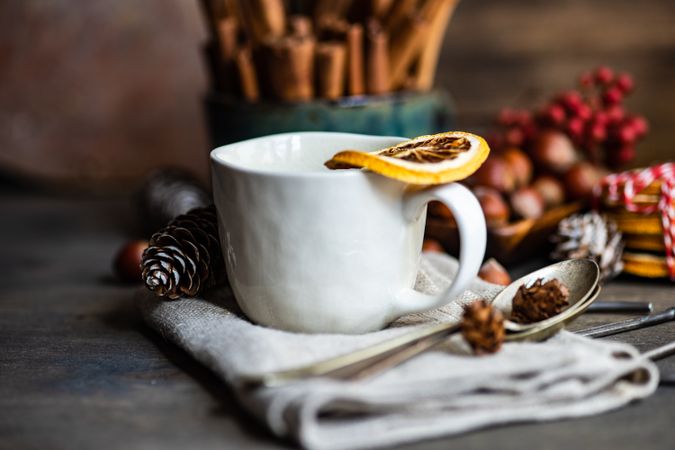 Dried orange slices balanced on mugs of wintry hot tea