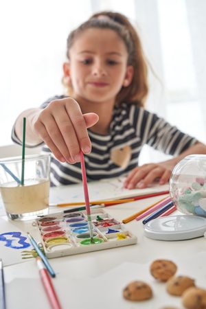 Girl with paints at table