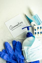Soap wrapped in facemask with pills, thermometer and latex gloves