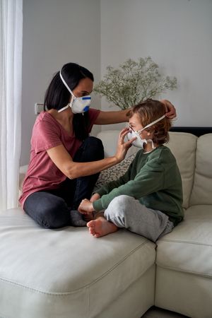 Mother and child in respirators at home