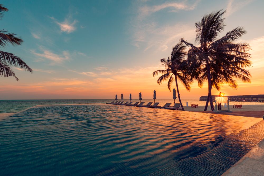 Lounge chairs lining a pool overlooking the Indian sea