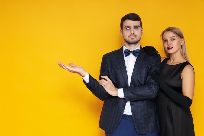 Concept of Halloween, young man and woman on yellow background