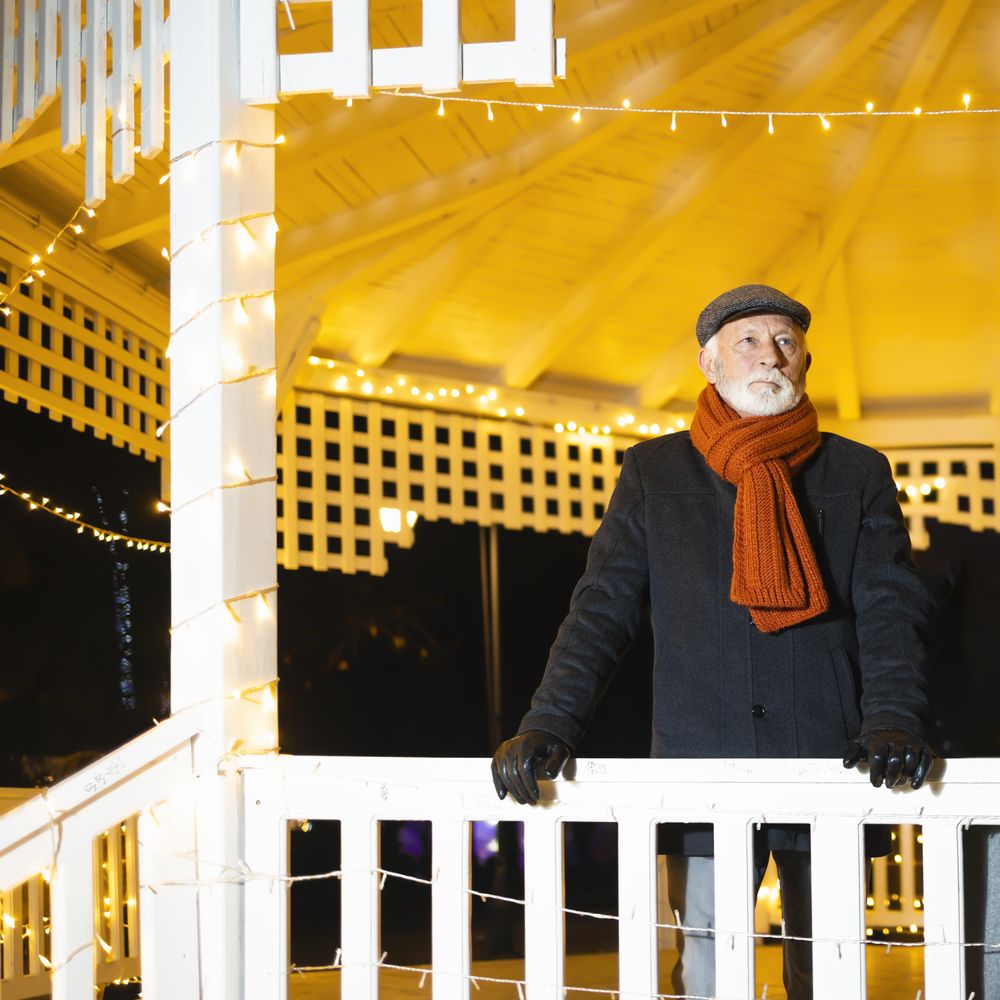 Grey haired man looking out from gazebo