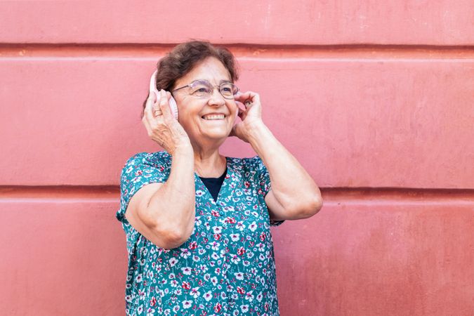 Mature woman in colorful clothes and modern headphones