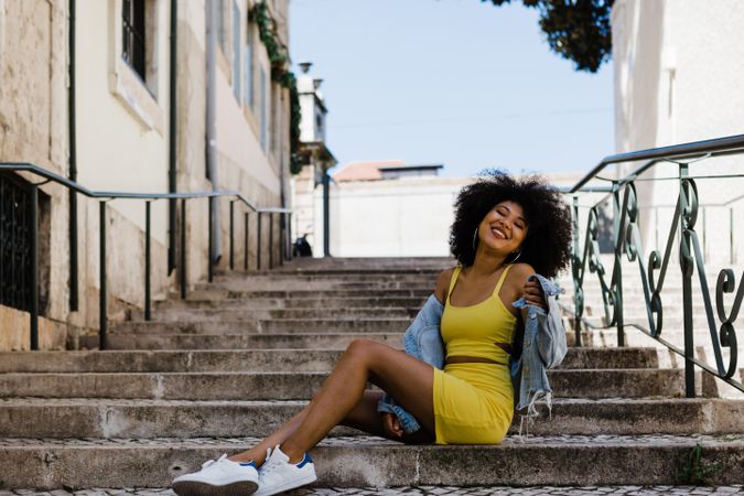 Stylish female standing in stairs with railing outdoors