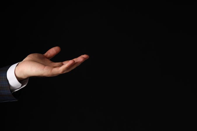 Businessman's hand close-up on a dark background