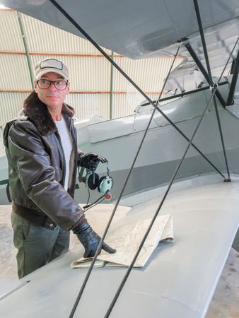 Pilot with map beside small plane