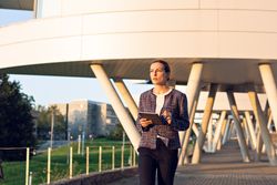 Confident entrepreneur with tablet on city street