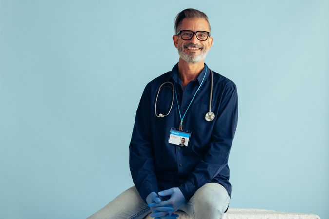 General practitioner with stethoscope looking at camera and smiling