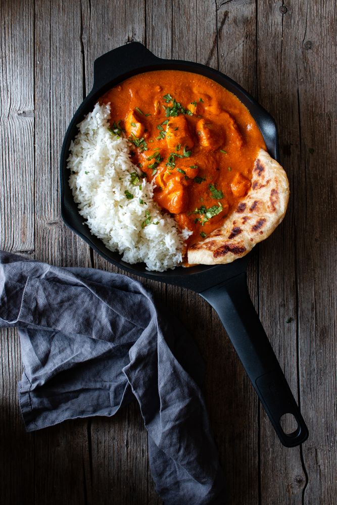 Close up of skillet full of delicious butter chicken and rice