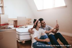 Excited boyfriend and girlfriend taking selfie in new apartment 477kB4