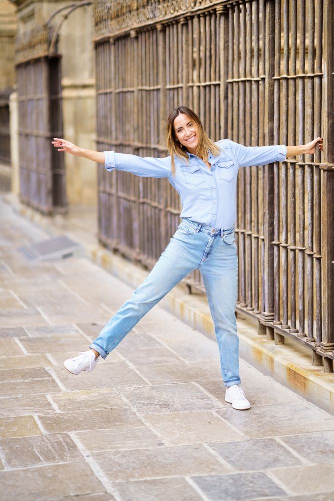 Playful woman grasping old fence