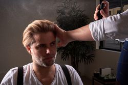 Barber spraying hair of customer