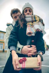 Woman holding giftbox from boyfriend holding her