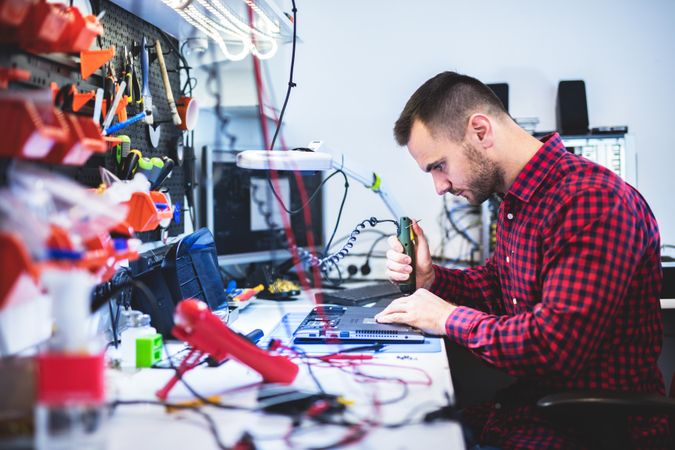 Man repairing laptop at workplace