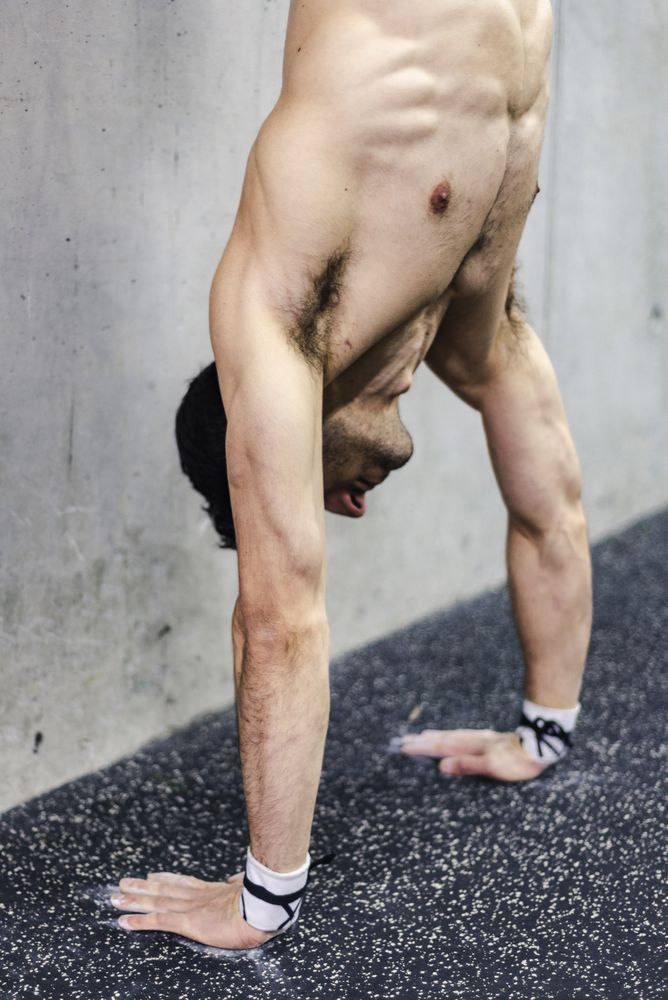 Man doing handstand in gym
